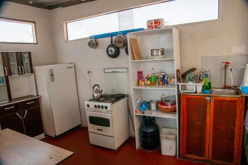 a small kitchen with a stove and a refrigerator at Hab Simple baño compartido Estudiante o Voluntario terraza vista a los Volcanes in Arequipa