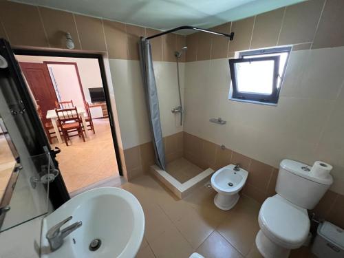 a bathroom with a toilet and a sink and a shower at Villa Bebi in Sarandë