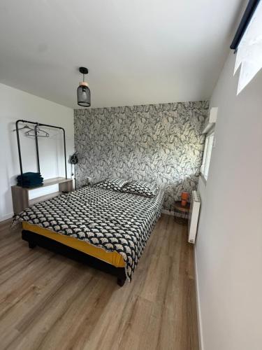 une chambre avec un lit et un miroir au mur dans l'établissement Appartement type 2 à corné, à Corné