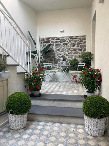 a porch with two potted plants and a staircase at Sa Troppa de sos chentu in Dorgali