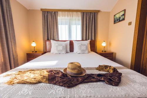 a bedroom with a bed with a hat on it at Hotel Albatros Old Town in Sozopol