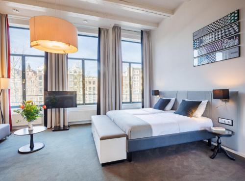 a bedroom with a king sized bed and a living room at Hapimag Apartments Amsterdam in Amsterdam