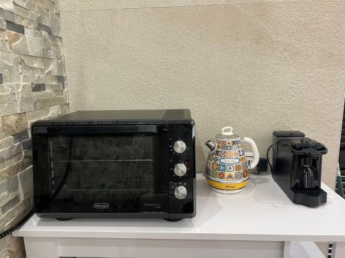 un forno a microonde appoggiato su un tavolo con una caffettiera di Naxos Room a Giardini Naxos