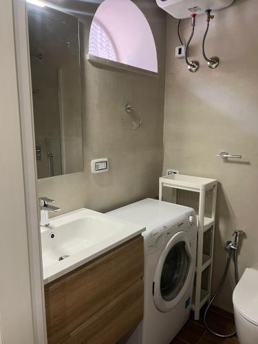 a bathroom with a washing machine and a sink at Naxos Room in Giardini Naxos