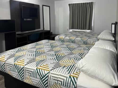 a hotel room with two beds and a television at Motel 6-Omaha, NE in Omaha