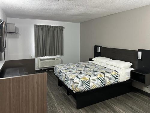 a bedroom with a bed and a sink in it at Motel 6-Omaha, NE in Omaha