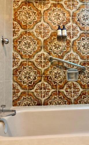 a bathroom with a tile wall with two lights on it at Hotel Nututun Palenque in Palenque