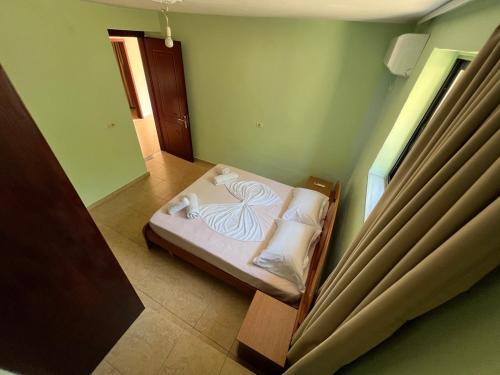 a small bedroom with a bed with white sheets and pillows at Villa Bebi in Sarandë