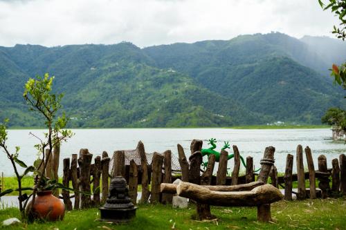 a wooden fence next to a body of water at Krazy Gecko Resort in Pokhara