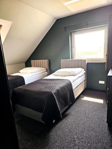 two beds in a room with a window at Willa za Zeliną 