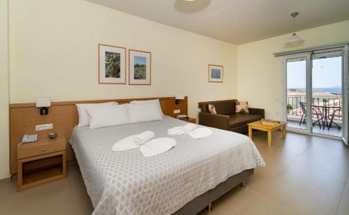 a bedroom with a bed with two towels on it at Hotel Estia in Finikounta
