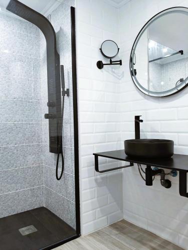a bathroom with a shower with a sink and a mirror at 100 Steps to the Sand. in La Tejita