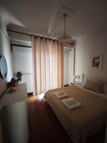 a bedroom with a bed with two towels on it at Cozy apartment in the city center in Katerini
