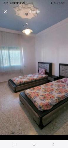 two beds in a room with two bedsitures at Sidi mahrsi Nabeul in Nabeul