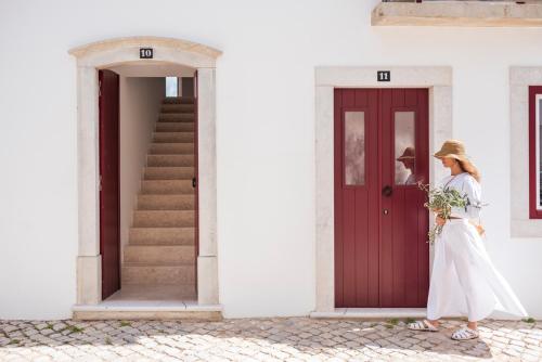 a woman walking out of a red door at Danna Portuguese Design House Porta 10 in Tavira