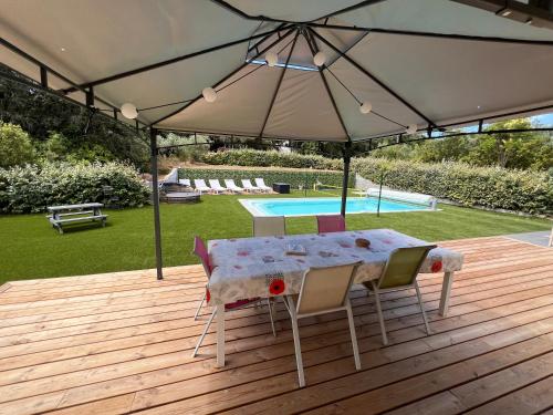 - une table et des chaises sur une terrasse en bois avec un parasol dans l'établissement Villa 4 chambres récente avec piscine et Jardin, à Lorgues