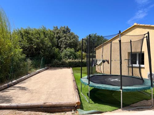 - un trampoline dans une cour à côté d'une maison dans l'établissement Villa 4 chambres récente avec piscine et Jardin, à Lorgues