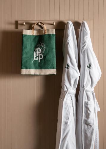 two white robes hanging on a wall with a flag at Le Petit Pali St Helena in St. Helena