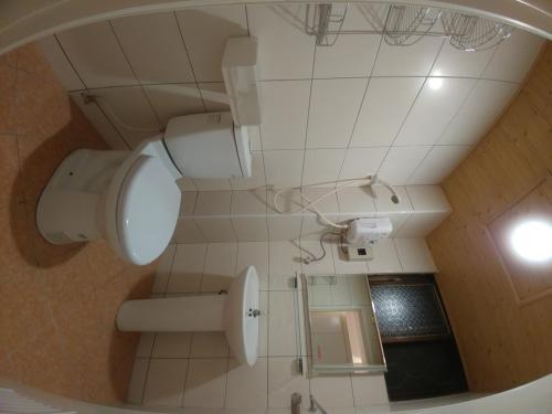 a bathroom with a toilet and a mirror at Rowan House in Taichung