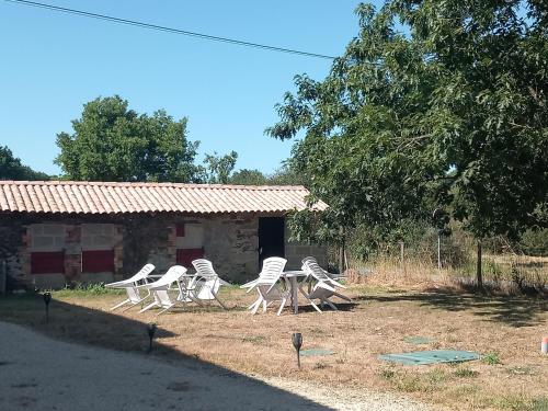 un groupe de chaises assises devant un bâtiment dans l'établissement Chambre hibiscus, à La Roche-sur-Yon