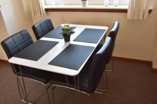 a white table with black chairs and a plant on it at City overnatning in Nørre Nebel