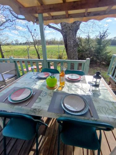 une table avec des plaques et des chaises sur une terrasse dans l'établissement Gorges du verdon Eden34, à Sainte-Croix-de-Verdon