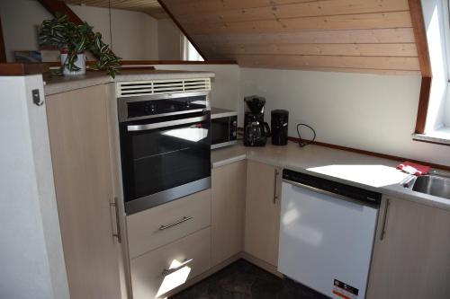 a small kitchen with a stove and a sink at City overnatning in Nørre Nebel