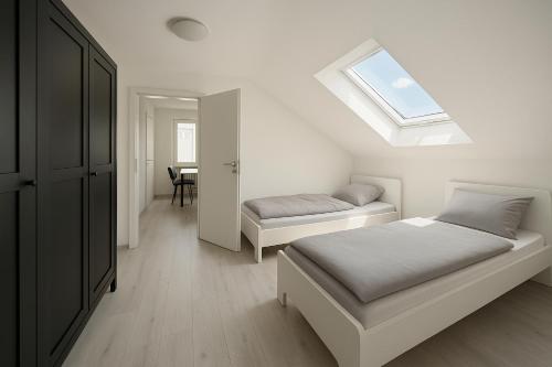 a bedroom with two beds and a skylight at Monteur- und Ferienwohnung Rheinhausen - Lönsweg in Oberhausen-Rheinhausen