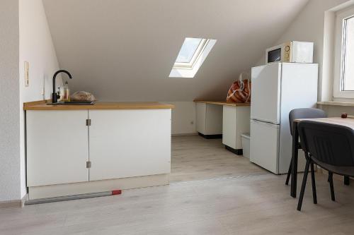a kitchen with white cabinets and a white refrigerator at Monteur- und Ferienwohnung Rheinhausen - Lönsweg in Oberhausen-Rheinhausen