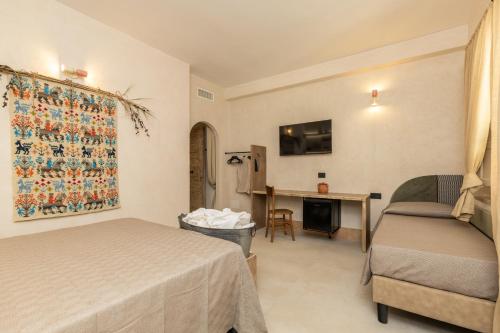 a bedroom with a bed and a desk with a chair at Bixinau Camere Museo in Tortolì
