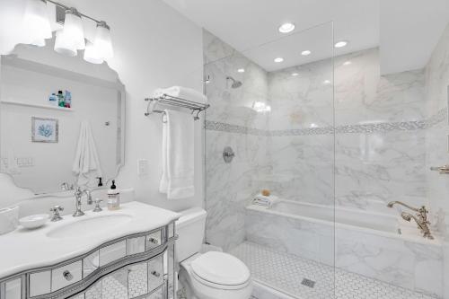 a white bathroom with a tub and a toilet and a sink at Island Time Casa Modern Key West Oasis W- Pool in Key West