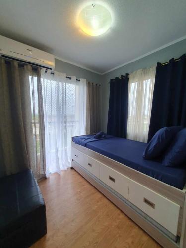 a bedroom with a large bed with blue sheets at Sanremo Oasis South Road Property Unit 4434 in Cebu City
