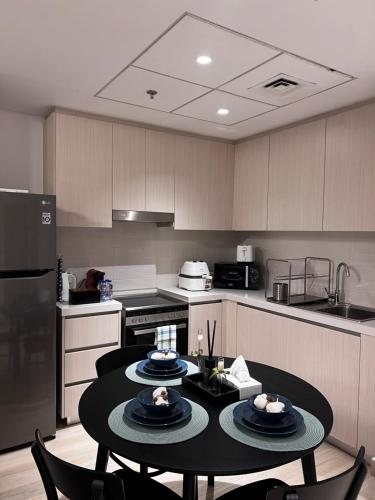 a kitchen with a table with plates on it at luxurious apartment 1BR Stay steps to Ferrari & Warner Bros Yas Mall in Yas Island