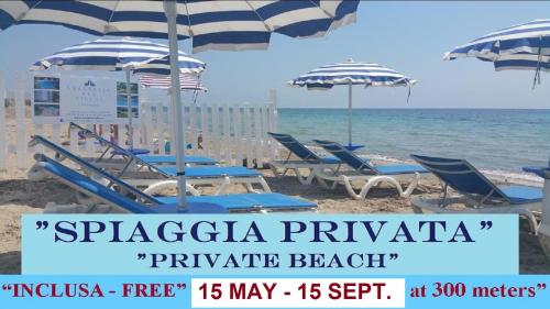 a group of beach chairs and umbrellas on a beach at Anastasia Villas-B&B in Lido Signorino
