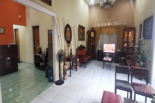 Una sala de estar con un sofá, una mesa y sillas. en Hotel O Classic Guesthouse, en Balikpapan