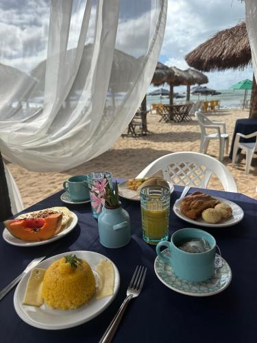 un tavolo blu con piatti di cibo sulla spiaggia di Pousada Makai a Porto De Galinhas