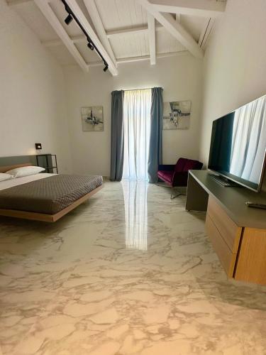 a bedroom with a bed and a flat screen tv at Liberty Palace in Milazzo
