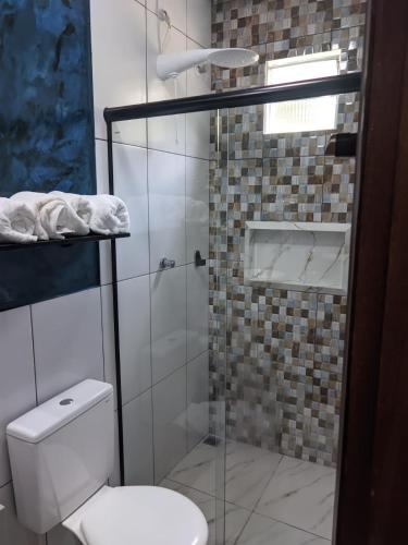 a bathroom with a toilet and a glass shower at POUSADA NOSSO CANTO ALTER in Alter do Chao