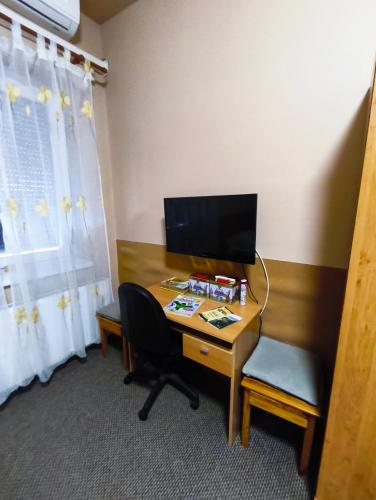 a desk with a computer and a chair in a room at Vár-Liget Vendégház in Kisnána