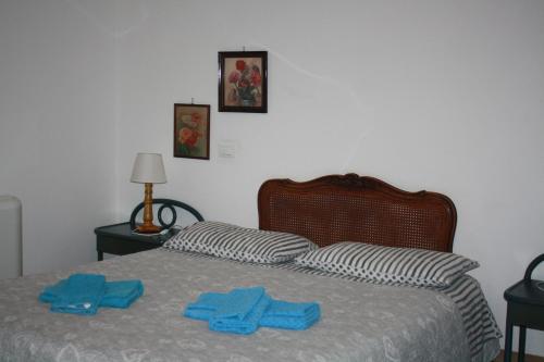 two towels on a bed with twoippers on it at La Quercia Agriturismo in Imperia