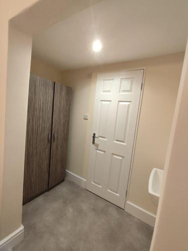 an empty bathroom with a door and a urinal at En-Suite Double-Bedroom in the Heart of Salford Manchester CR2 Perfect for Short Stays in Manchester