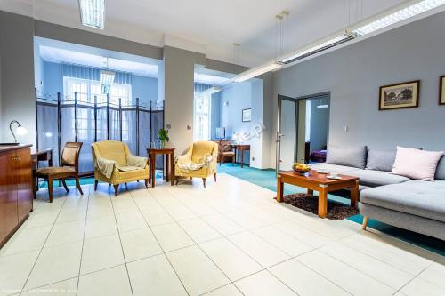a living room with a couch and chairs and a table at VILLA CAPITOL in Ostróda