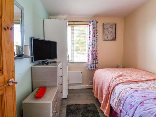 a bedroom with a bed and a flat screen tv at Sandbay in Bridlington