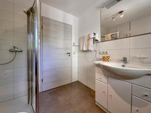 a white bathroom with a sink and a shower at Mit Herz in Viechtach