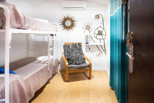 ein Schlafzimmer mit einem Etagenbett und einem Stuhl in der Unterkunft Backpacker Al-Katre in Córdoba