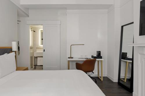 a bedroom with a bed and a desk and a chair at Newly Renovated Rooms at Club Quarters Hotel Times Square, New York in New York
