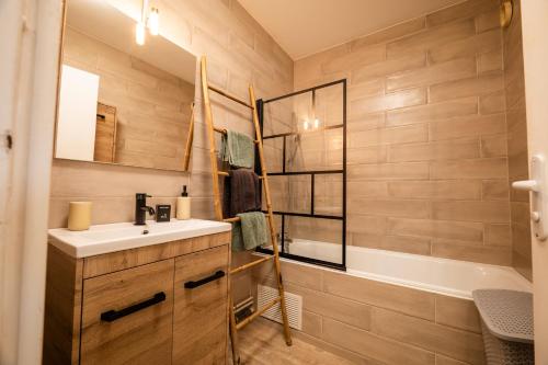 une salle de bain avec un lavabo et une baignoire dans l'établissement Charmant appartement - Box Gourmande -parking -Clim, à Perpignan