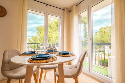 une salle à manger avec une table et des chaises et une fenêtre dans l'établissement Charmant appartement - Box Gourmande -parking -Clim, à Perpignan