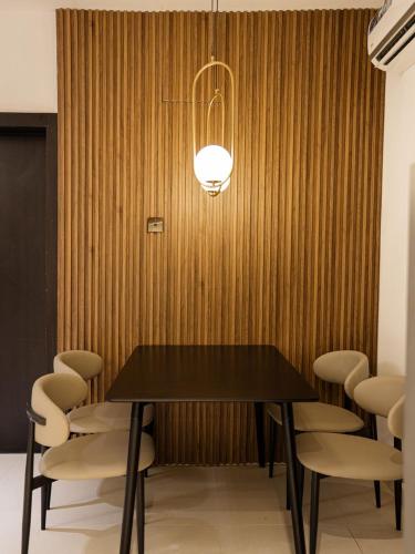 a dining room with a black table and chairs at The Hudson Apartments in Ilado