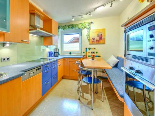 a kitchen with blue cabinets and a small table at Innradweg in Angath